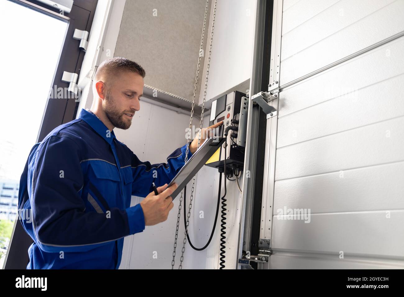 Garagentor Installation Und Reparatur Zu Hause. Auftragnehmer Mann Im Haus Stockfoto