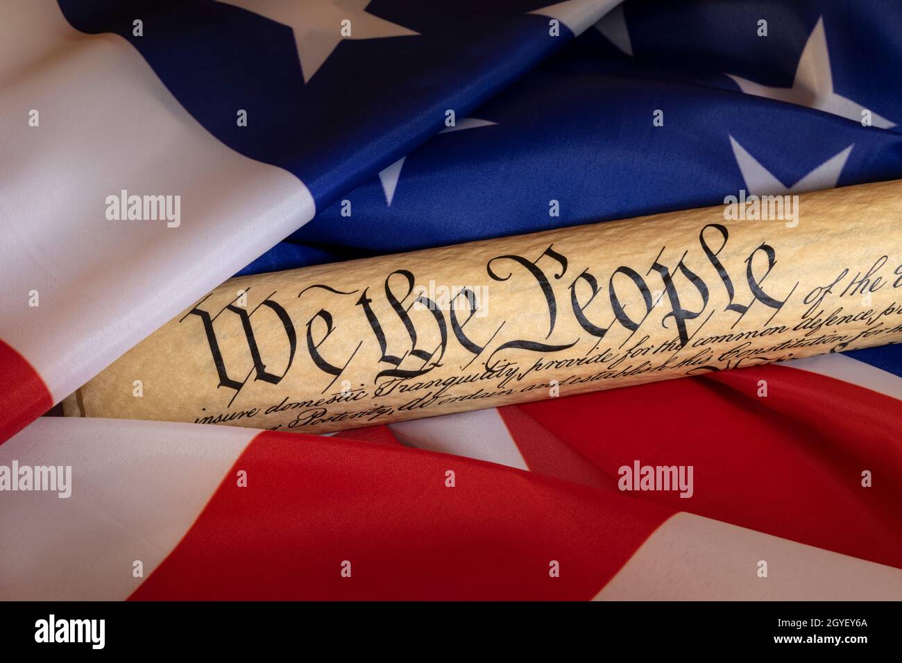 Die von der amerikanischen Flagge umrahmte Verfassung symbolisiert ein Land der Gesetze, die Freiheit und Wohlstand befürworten. Stockfoto