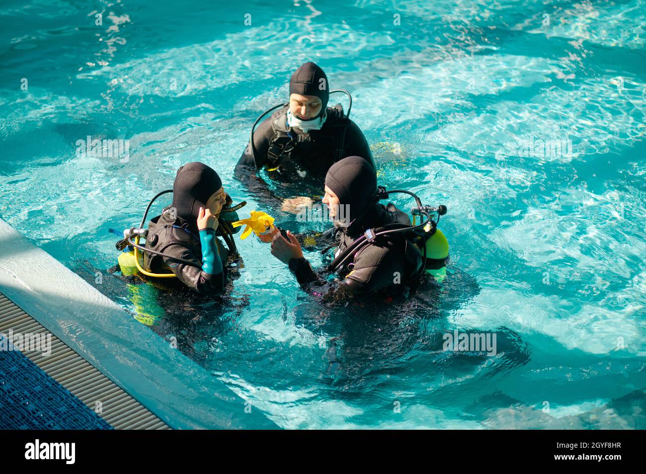 Tauchlehrer und zwei Taucher in den Aqualungs, Tauchkurs in der  Tauchschule. Unterwasser-Schwimmen mit Tauchausrüstung, Hallenbad mit  Innenbecken Stockfotografie - Alamy