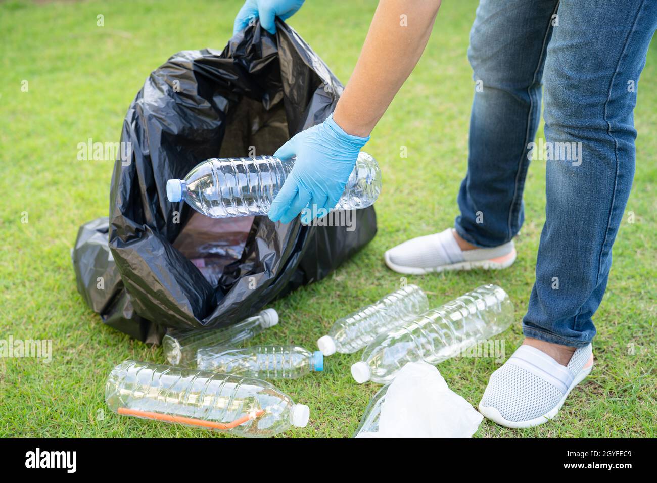 Asiatische Frau Freiwillige tragen Wasser Plastikflaschen in Müllbeutel Müll im Park, recyceln Abfall Umwelt Ökologie Konzept. Stockfoto