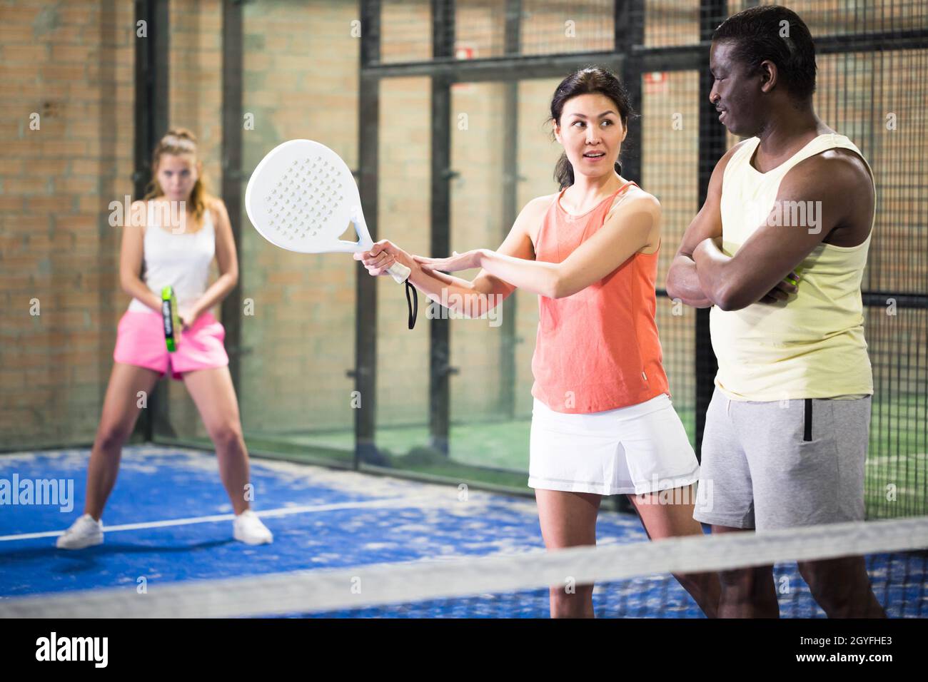 Eine Frau, die Tennis spielt und erfahrene Spieler nach Technik fragt Stockfoto
