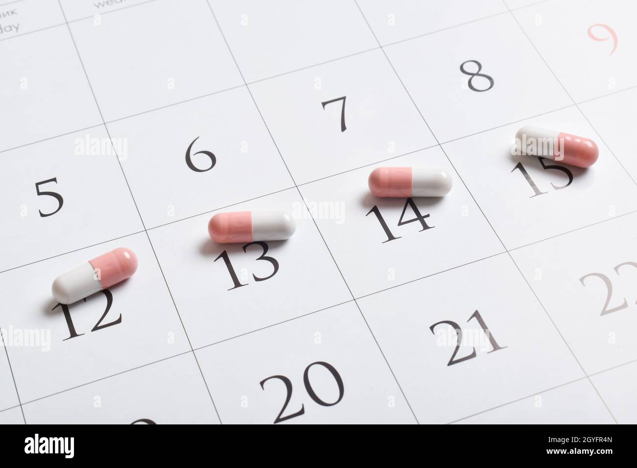 Medikamente. Rosa pharmazeutische Kapseln mit Tabletten stehen im Kalender. Ein Konzept für 