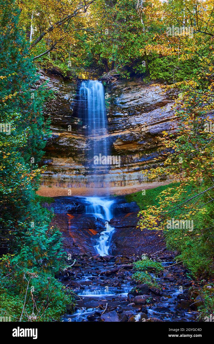 Munising Falls Wasserfall mit nebligen Wasserfall und roten und violetten Steinen am Becken Stockfoto