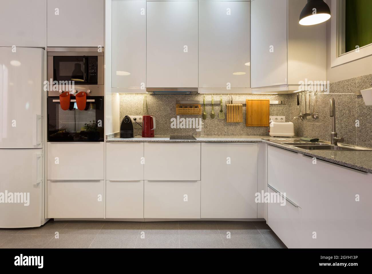 Stilvolles Interieur der modernen Küche mit Marmortisch und Haushaltsgeräten. Stockfoto