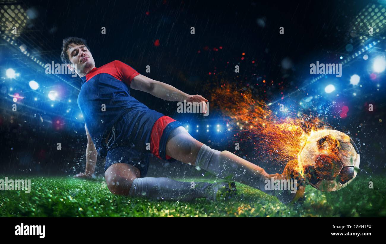 Kraftvoller Kick eines Fußballspielers mit feurigem Ball Stockfoto