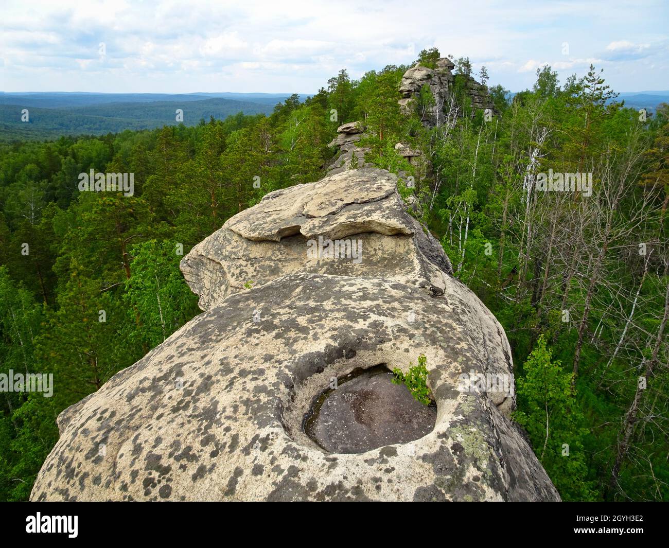 Felsen mit abhängenden Kanten und einer Steinschale, Herbst. Granitfelsen-Massiv des Mittleren Urals - Berg Arakulskie Shikhany, Tscheljabinsk Region, Russland. Stockfoto