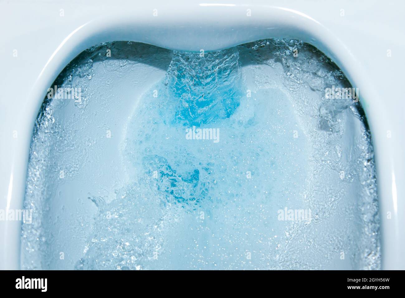 Wasser läuft im Abfluss nach unten. Toilettenschüssel spülen mit blauer  Reinigungsflüssigkeit. Reinigung Toilette Nahaufnahme. Umweltverschmutzung  und Wassersparkonzept Stockfotografie - Alamy