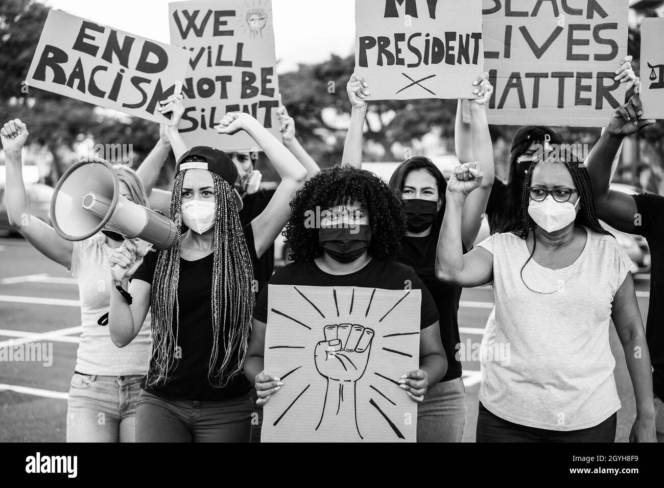 Demonstrator Menschen aus verschiedenen Kulturen und Rassen protestieren auf der Straße für Gleichberechtigung in Masken - Fokus auf Center Girl Stockfoto