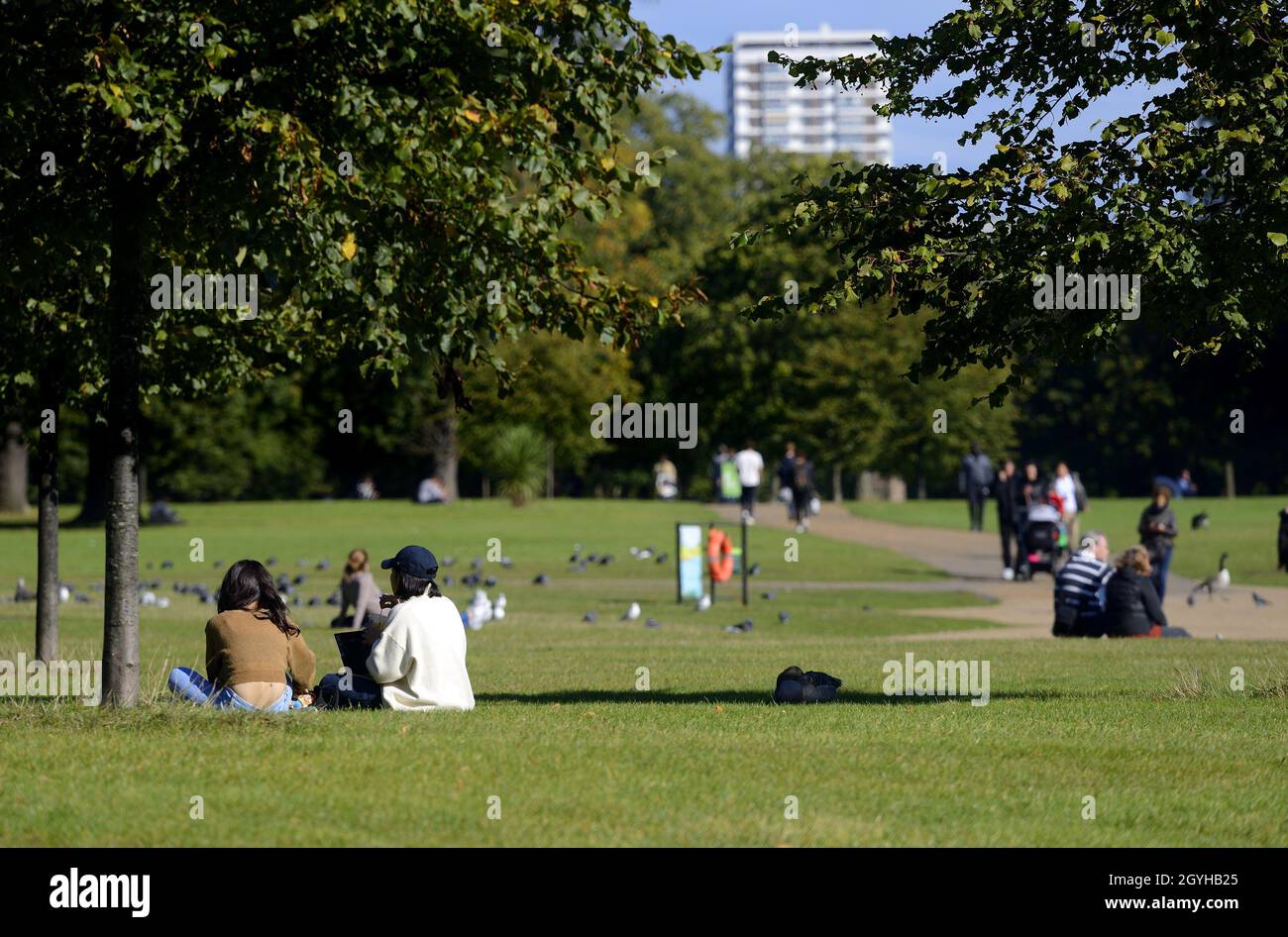 London, England, Großbritannien. Kensington Gardens: Menschen, die sich in der Oktobersonne entspannen, 2021 Stockfoto