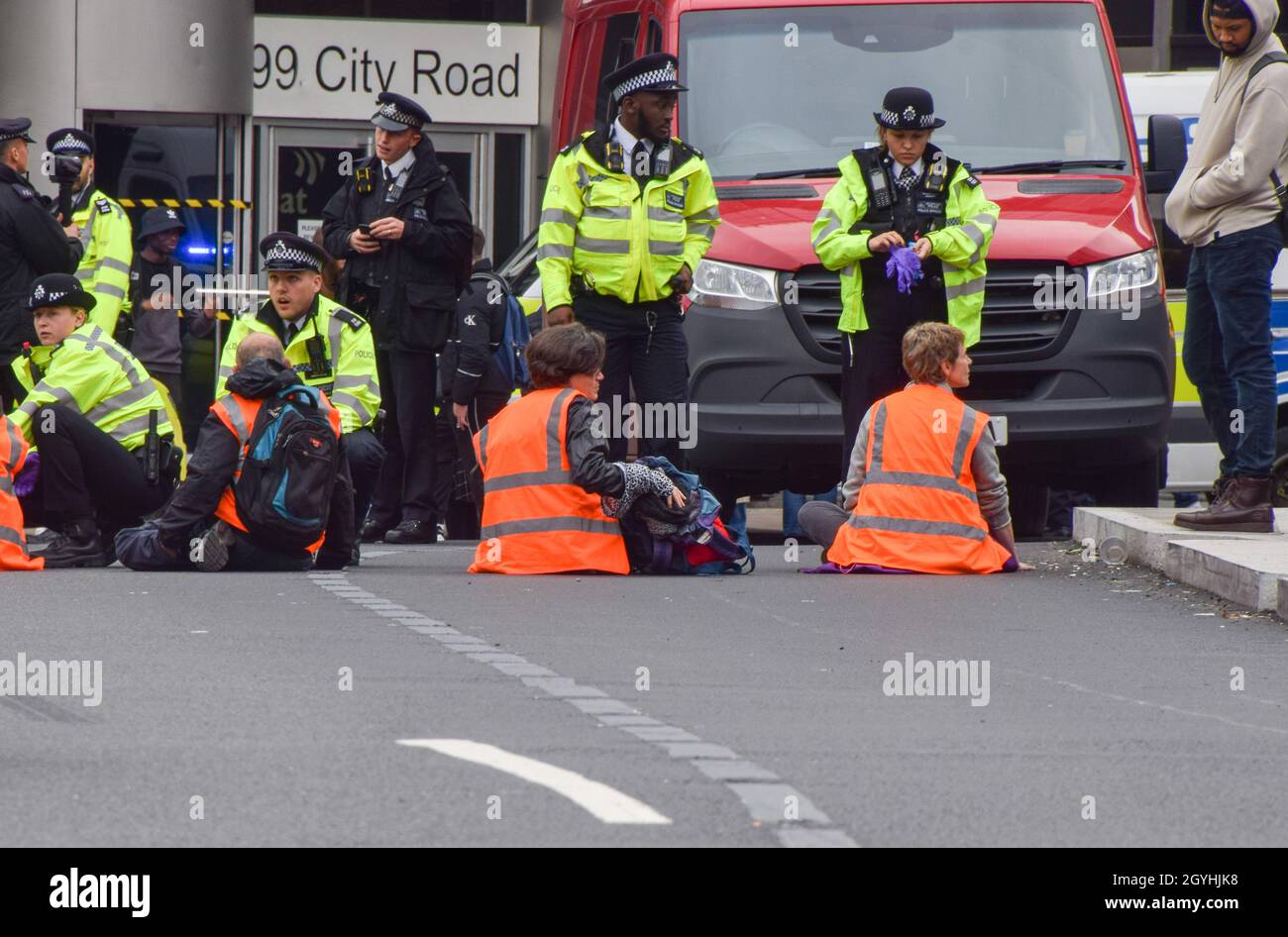 London, Großbritannien. Okt. 2021. Die Polizei entfernt und verhaftet britische Demonstranten, die sich am Kreisverkehr in der Old Street an die Straße geklebt haben. Beleidigung Großbritanniens die Demonstranten fordern, dass die Regierung bis 2025 alle sozialen Wohnungsbauten isoliert und die Verantwortung dafür übernimmt, dass alle Häuser im Vereinigten Königreich bis 2030 energieeffizienter sind, als Teil der umfassenderen Ziele für den Klimawandel und die Dekarbonisierung. Kredit: Vuk Valcic/Alamy Live Nachrichten Stockfoto