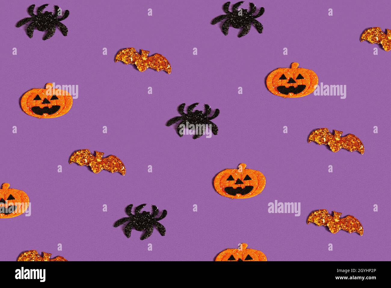 Kreatives lila Muster aus Kürbis, Fledermaus und Spinnen. Halloween-Konzept flach, Draufsicht, Kopierraum Stockfoto