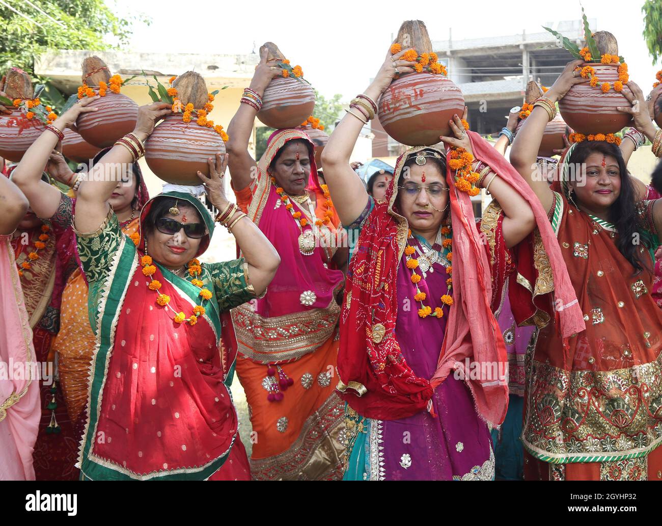 Beawar, Indien. Oktober 2021. Beawar, Rajasthan, Indien, 7. Oktober 2021: Rajasthani Frauen tragen Tontöpfe gefüllt mit heiligem Wasser während kalash yatra am ersten Tag des 9-tägigen Navratri-Festivals in Beawar. Das Navratri-Fest markiert den Sieg der Göttin Durga über den bösen Büffeldämon Mahishasura. So verkörpert das Durga Puja Festival den Sieg des Guten über das Böse in der hinduistischen Mythologie, gipfelt im Eintauchen von Idolen in Gewässer. Das Festival wird bis zum 15. Oktober fortgesetzt. Kredit: Sumit-Samarwat/Alamy Live Nachrichten Stockfoto