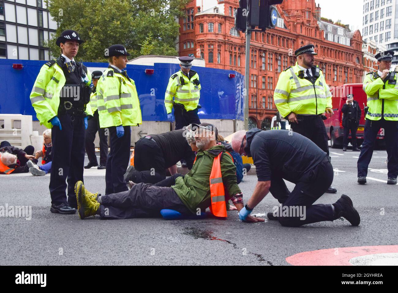 London, Großbritannien. Oktober 2021. Die Polizei entfernt und verhaftet britische Demonstranten, die sich am Kreisverkehr in der Old Street an die Straße geklebt haben. Beleidigung Großbritanniens die Demonstranten fordern, dass die Regierung bis 2025 alle sozialen Wohnungsbauten isoliert und die Verantwortung dafür übernimmt, dass alle Häuser im Vereinigten Königreich bis 2030 energieeffizienter sind, als Teil der umfassenderen Ziele für den Klimawandel und die Dekarbonisierung. Kredit: Vuk Valcic / Alamy Live Nachrichten Stockfoto