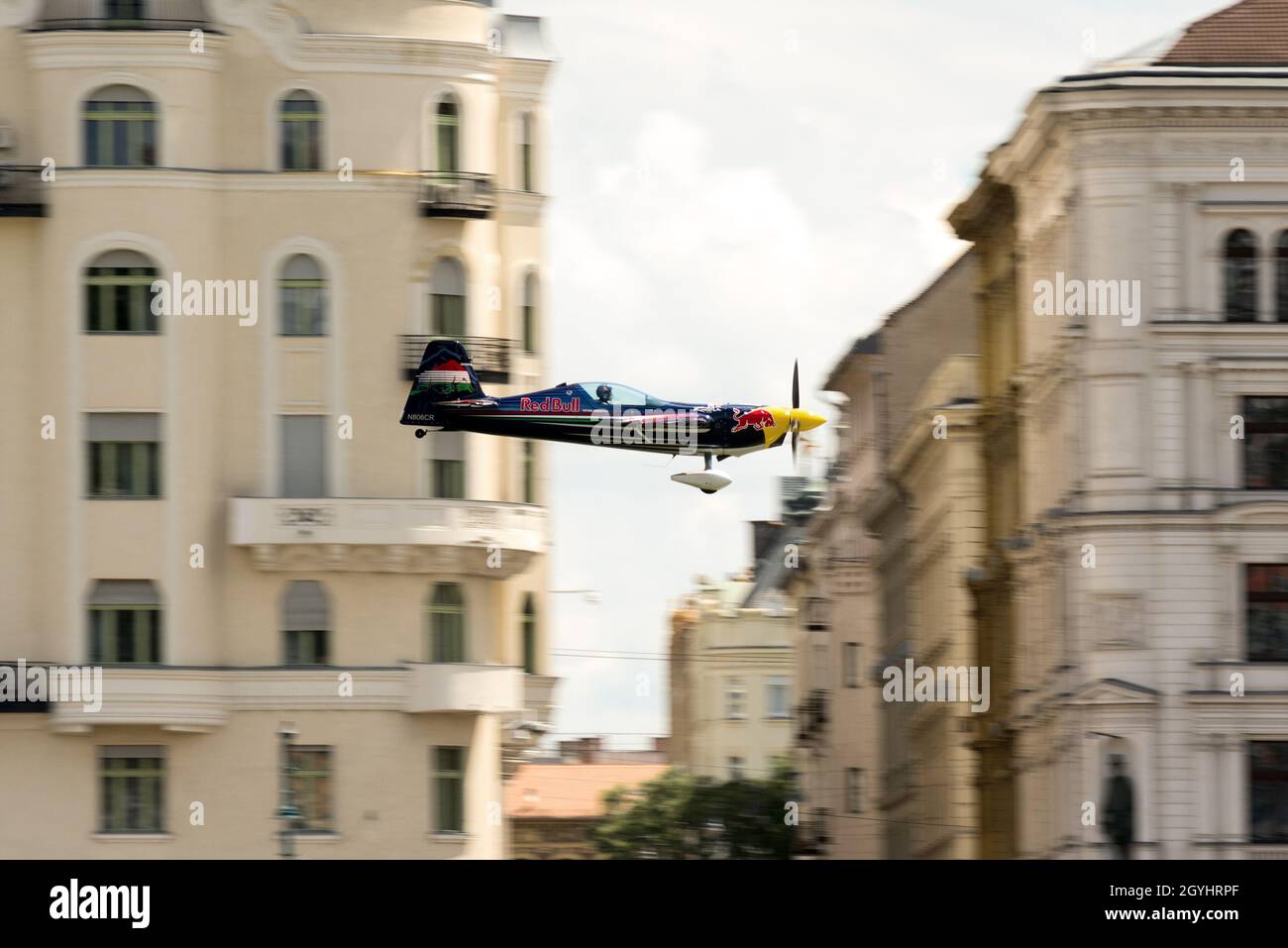 Ein Propellerflugzeug, das tief gegen das alte Stadtgebäude fliegt. Red Bull Air Race in Budapest, 24. juni 2018 Stockfoto