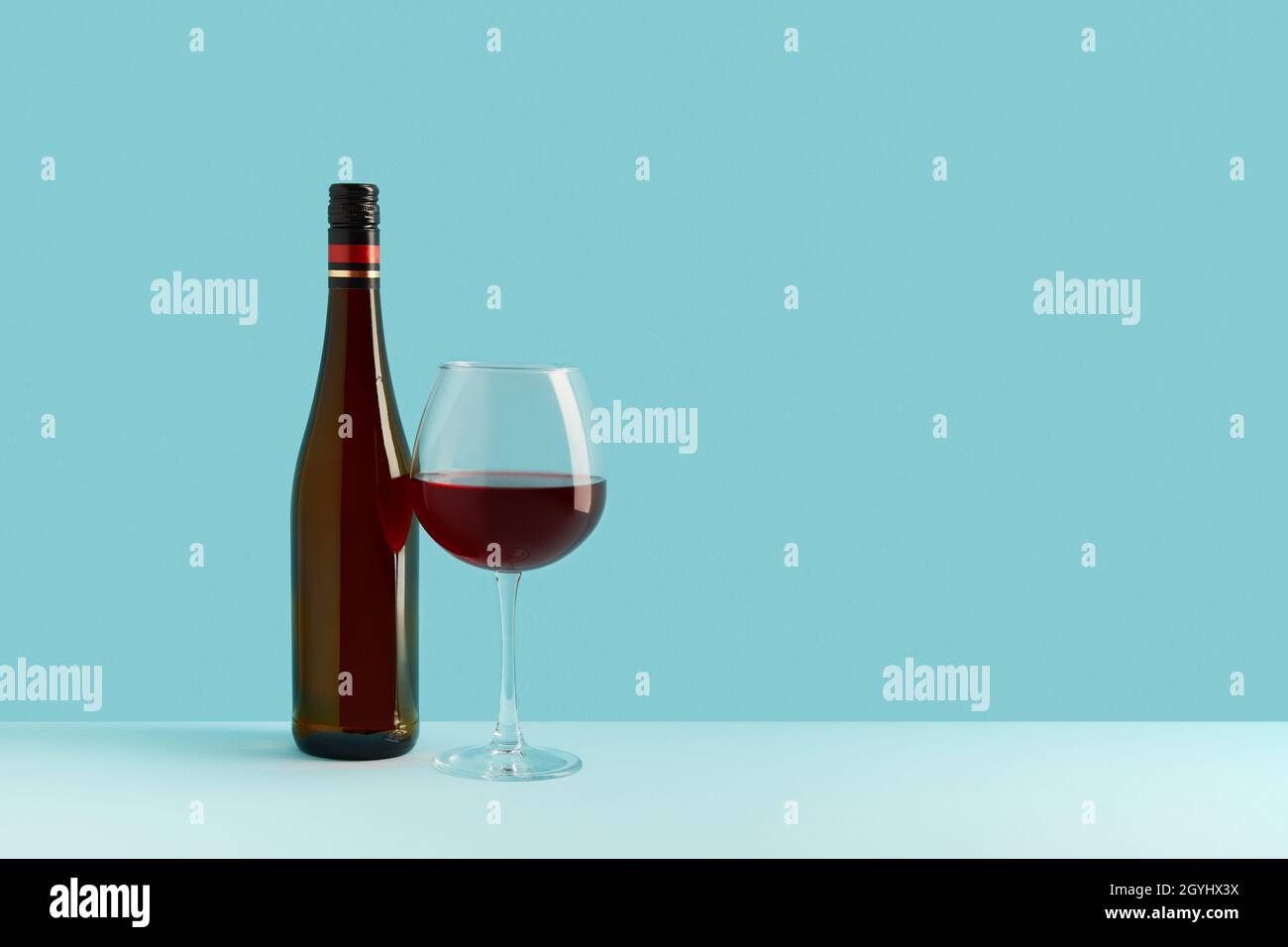 Flasche und Glas Rotwein auf blauem Hintergrund. Mock up Drink mit Platz für Sie Lable und Text Stockfoto