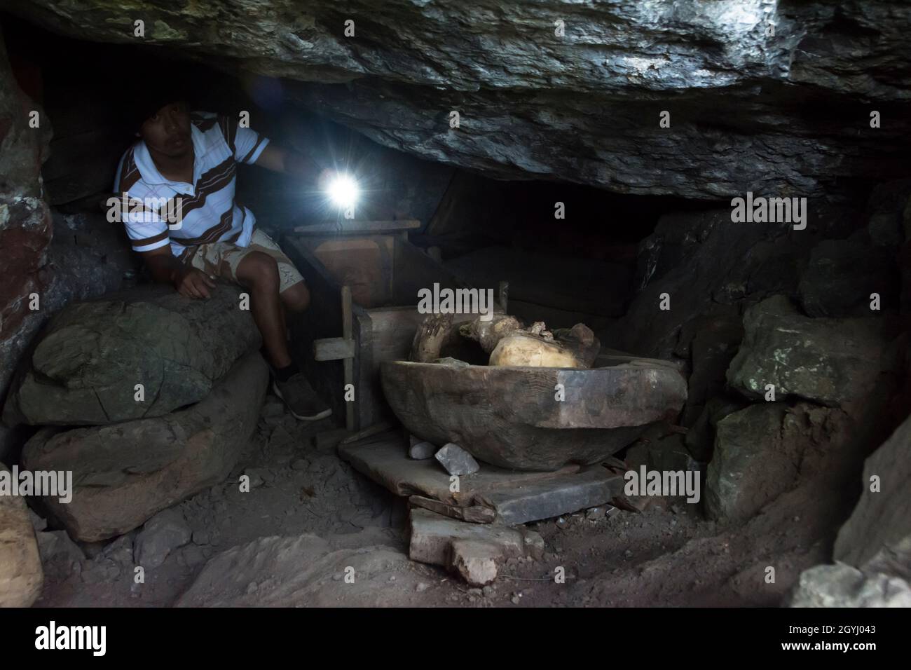 Ein Mann zeigt seine Taschenlampe auf eine Feuermumie der Ibaloi-Leute, die in einer der Höhlen in der Nähe von Kabayan gefunden wurde. Luzon, Philippinen. Stockfoto