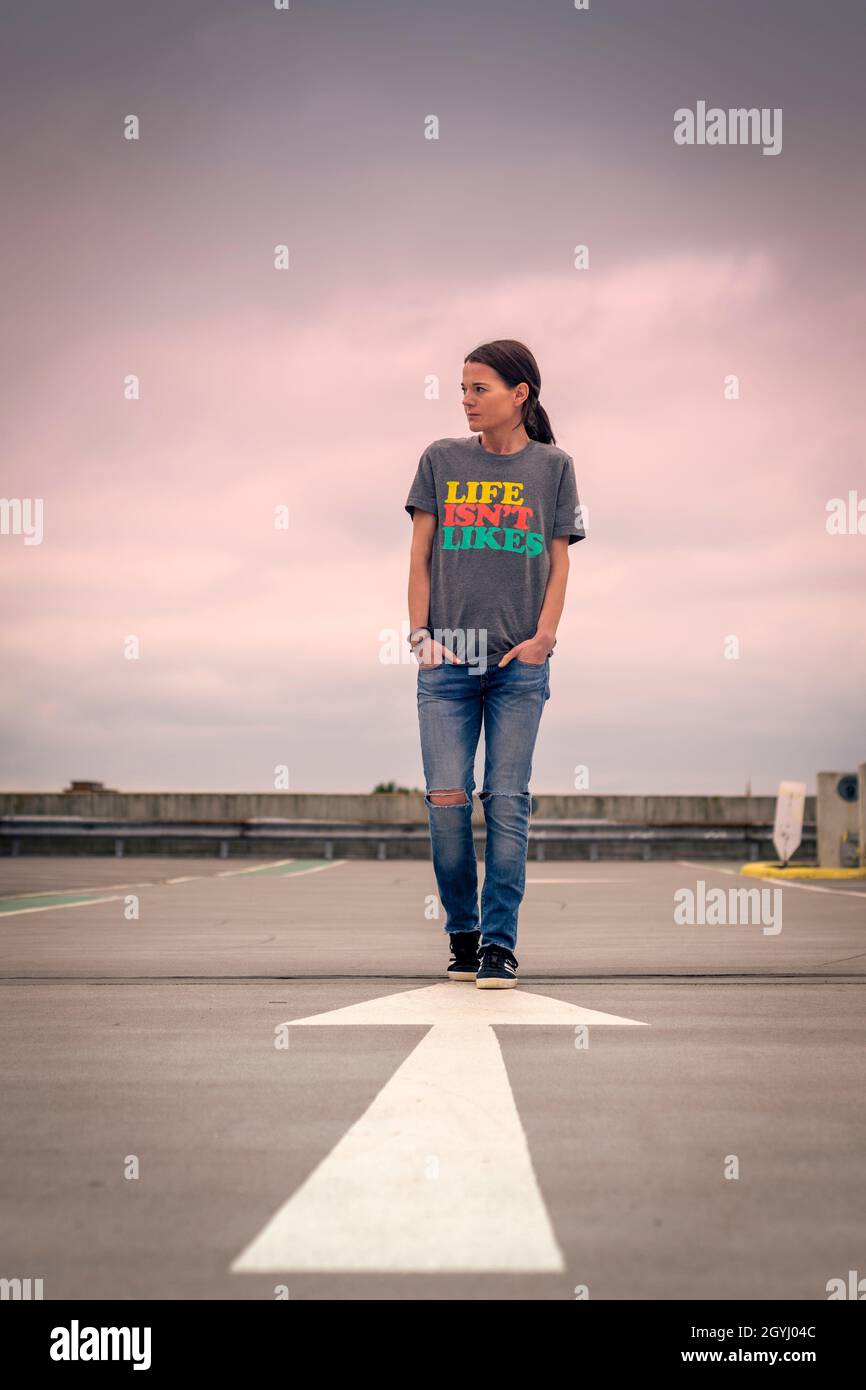 Attraktive Frau in einem T-Shirt mit „Life is't Likes“-Schriftzug auf der Vorderseite, Stockfoto
