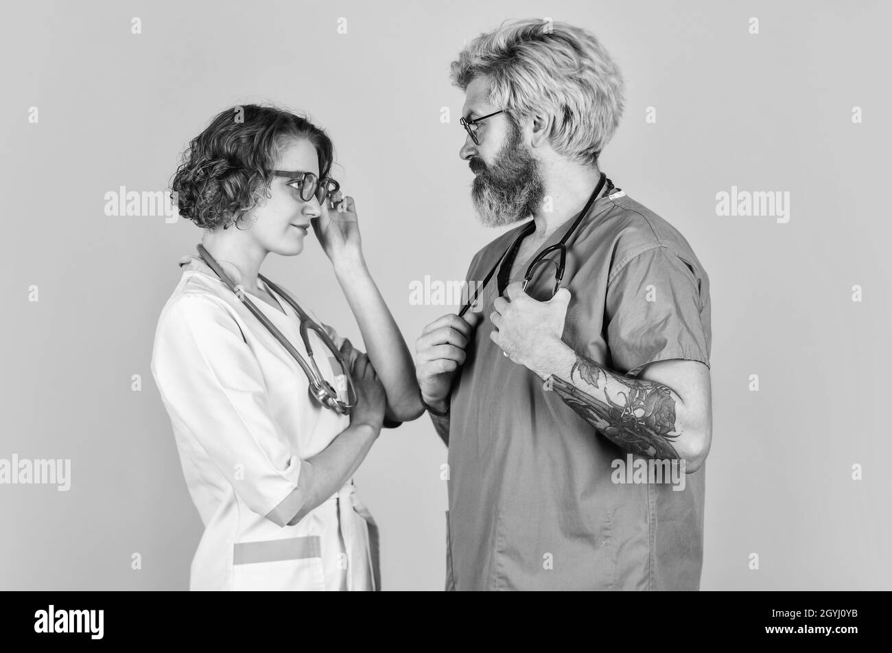 Menschen in Uniformen gelben Hintergrund. Medizinisches Personal. Vertrauen Sie unseren Fachleuten. Healthcare Business. Teamarbeit und Menschen Konzept. Arzt und Krankenschwester Stockfoto