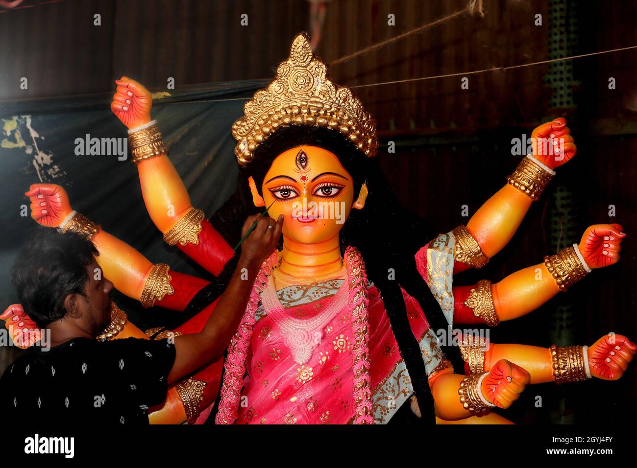 Ein Handwerker bringt dem Idol der Göttin Durga, der wichtigsten Gottheit im Hinduismus, den letzten Schliff als Durga Puja, dem größten religiösen Fest Stockfoto