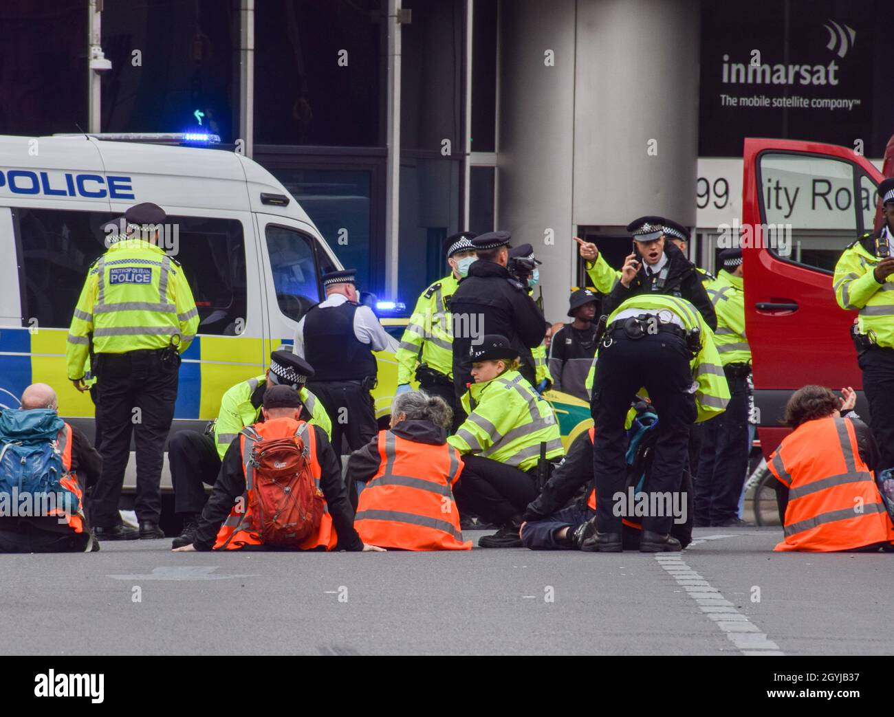 London, Großbritannien. Oktober 2021. Die Polizei entfernt und verhaftet britische Demonstranten, die sich am Kreisverkehr in der Old Street an die Straße geklebt haben. Beleidigung Großbritanniens die Demonstranten fordern, dass die Regierung bis 2025 alle sozialen Wohnungsbauten isoliert und die Verantwortung dafür übernimmt, dass alle Häuser im Vereinigten Königreich bis 2030 energieeffizienter sind, als Teil der umfassenderen Ziele für den Klimawandel und die Dekarbonisierung. Stockfoto