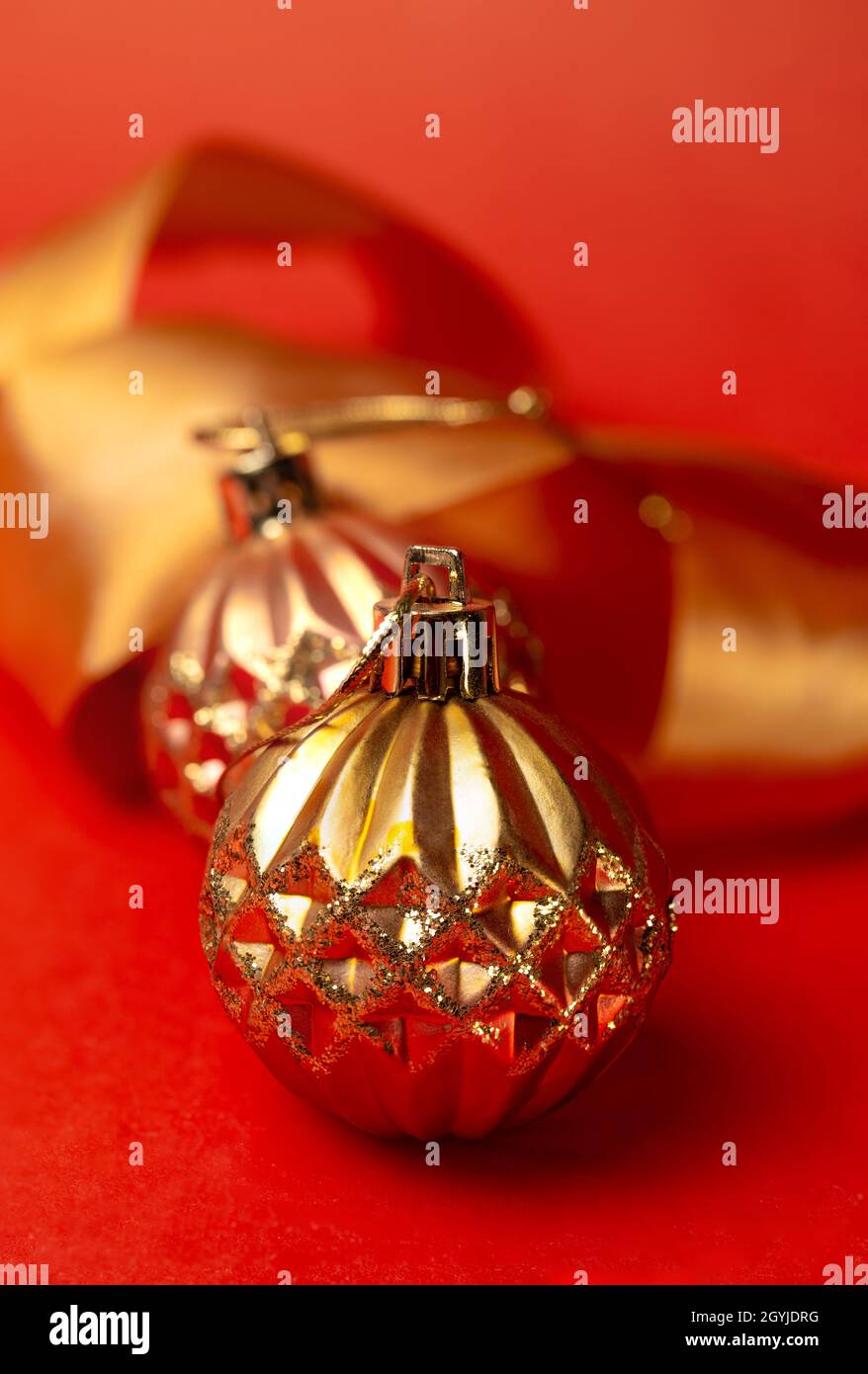goldene runde Weihnachtsspielzeuge auf rotem Hintergrund Stockfoto