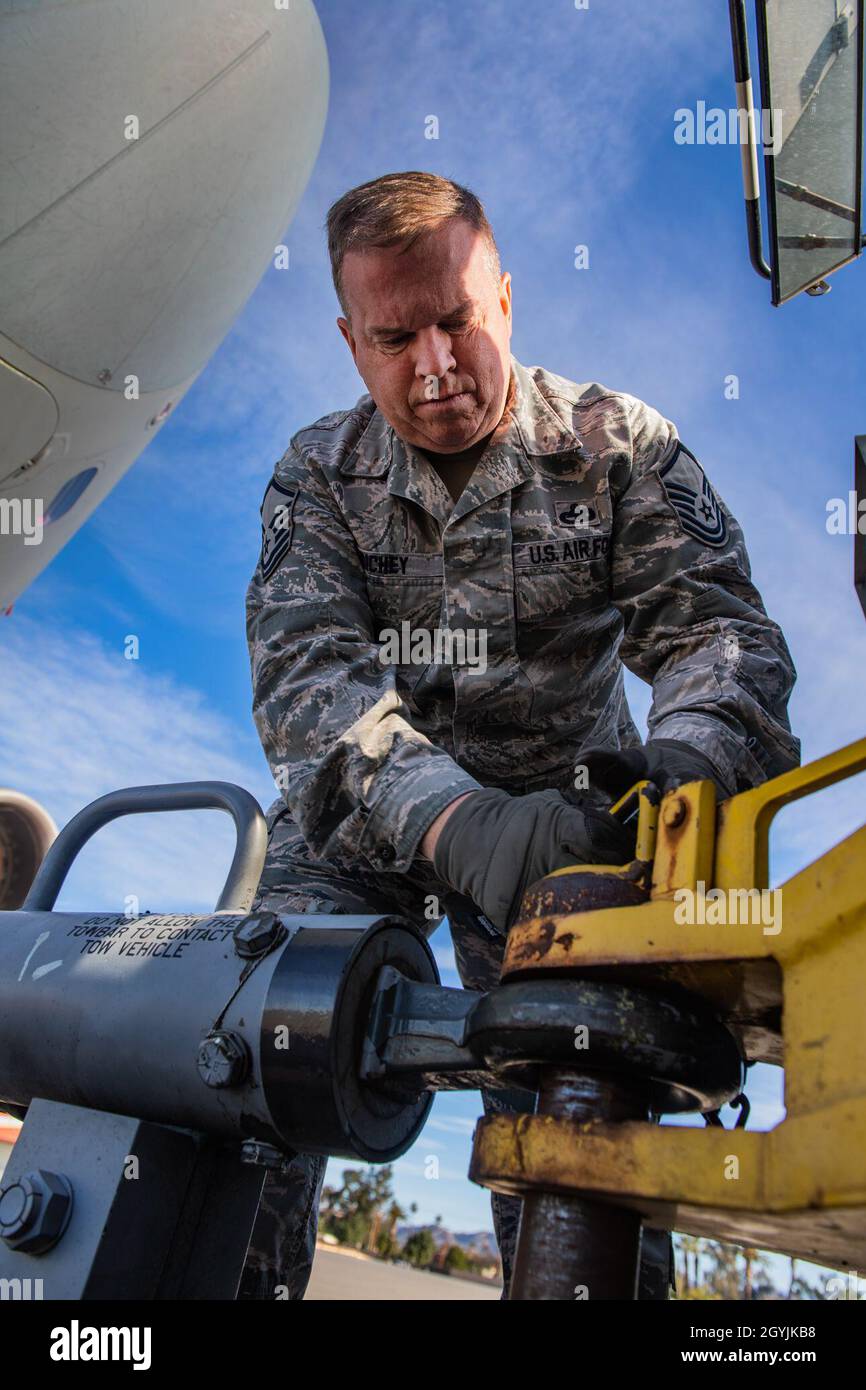 Master-Sgt. Bill Richey, Besatzungsmacht der 911. Flugzeugwartung, schließt eine Abschleppstange ein, die an einem C-17 Globemaster III an einem Abschleppfahrzeug auf der March Air Reserve Base, Kalifornien, am 7. Januar 2020 befestigt ist. Damit das Flugzeug gewaschen werden konnte, musste es zunächst an den Waschraum geschleppt werden, der sich in einem anderen Bereich der Fluglinie befindet. (USA Luftstreitkräfte-Foto von Joshua J. Seybert) Stockfoto