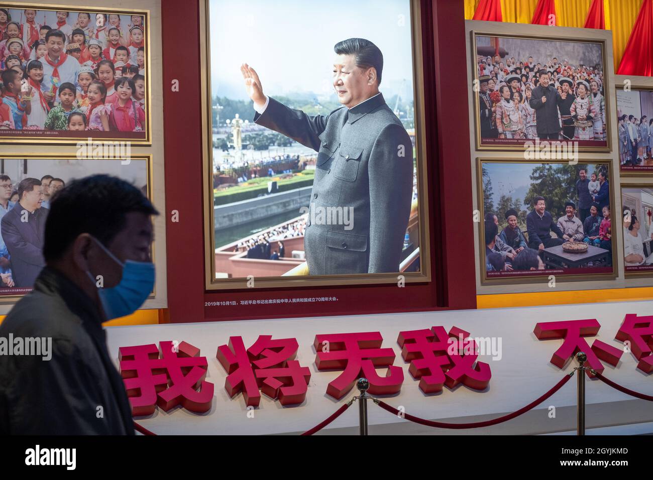 Ein Mann geht an Bildern vorbei, die den chinesischen Präsidenten Xi Jinping im Museum der Kommunistischen Partei Chinas in Peking zeigen. 08-Okt-2021 Stockfoto