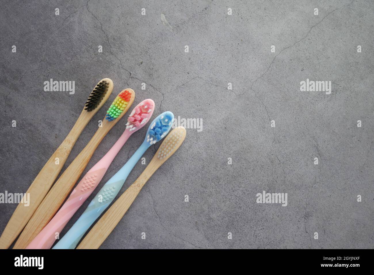 Bunte Zahnbürsten auf schwarzem Hintergrund mit Kopierfläche Stockfoto