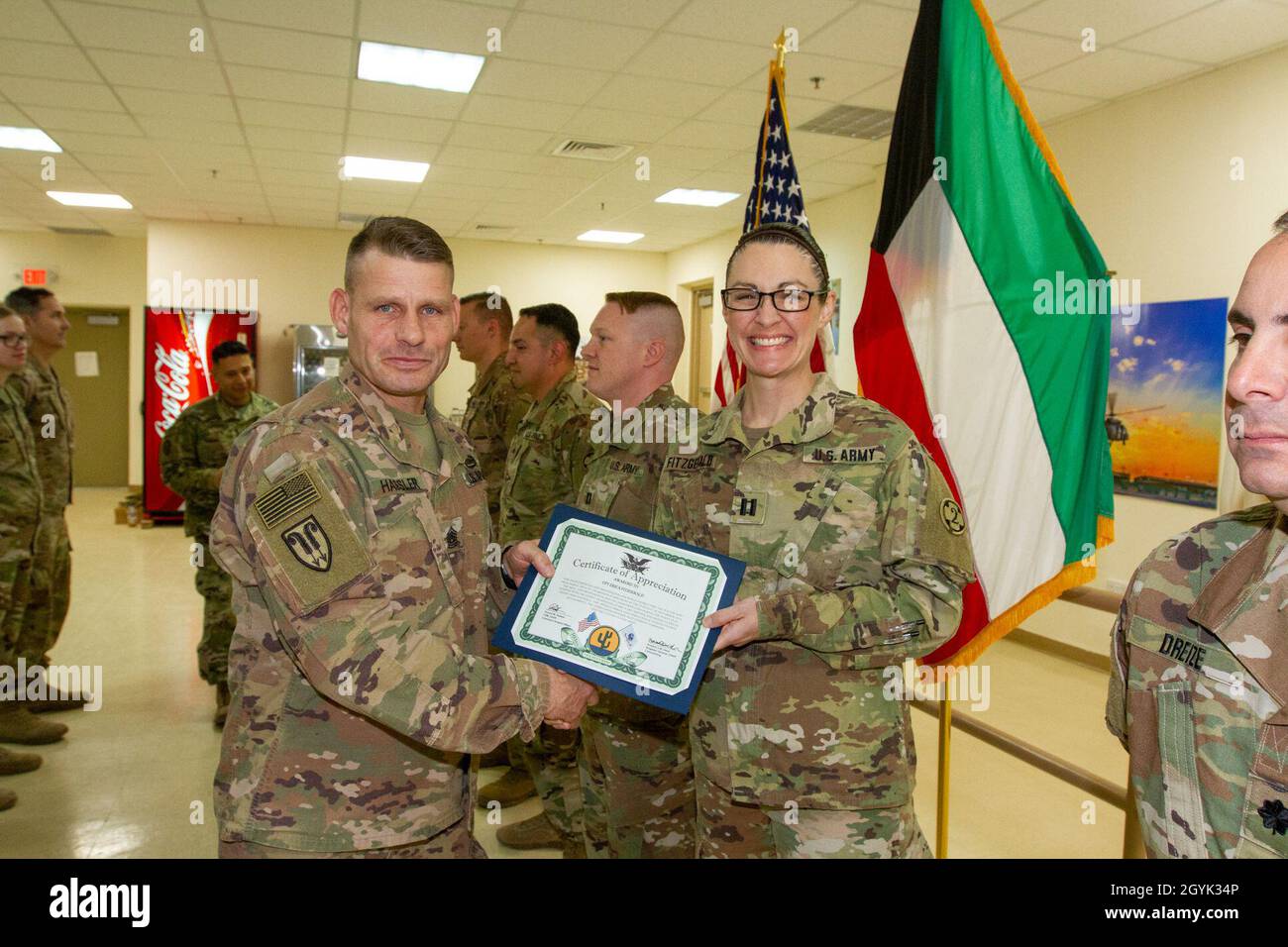 Befehl Sgt. Maj. Ronald Hassler, Senior Enlisted Advisor, 103. Expeditionary Sustainment Command (ESC), überreicht Capt. Erica Fitzgerald, 349. Combat Support Hospital, eine Dankesurkunde für ihre Arbeit am Symposium zur Selbstmordsensibilisierung und Prävention im Camp Arifjan, Kuwait, am 13. Januar 2020. (USA Foto der Armee von Staff Sgt. Godot G. Galgano) Stockfoto