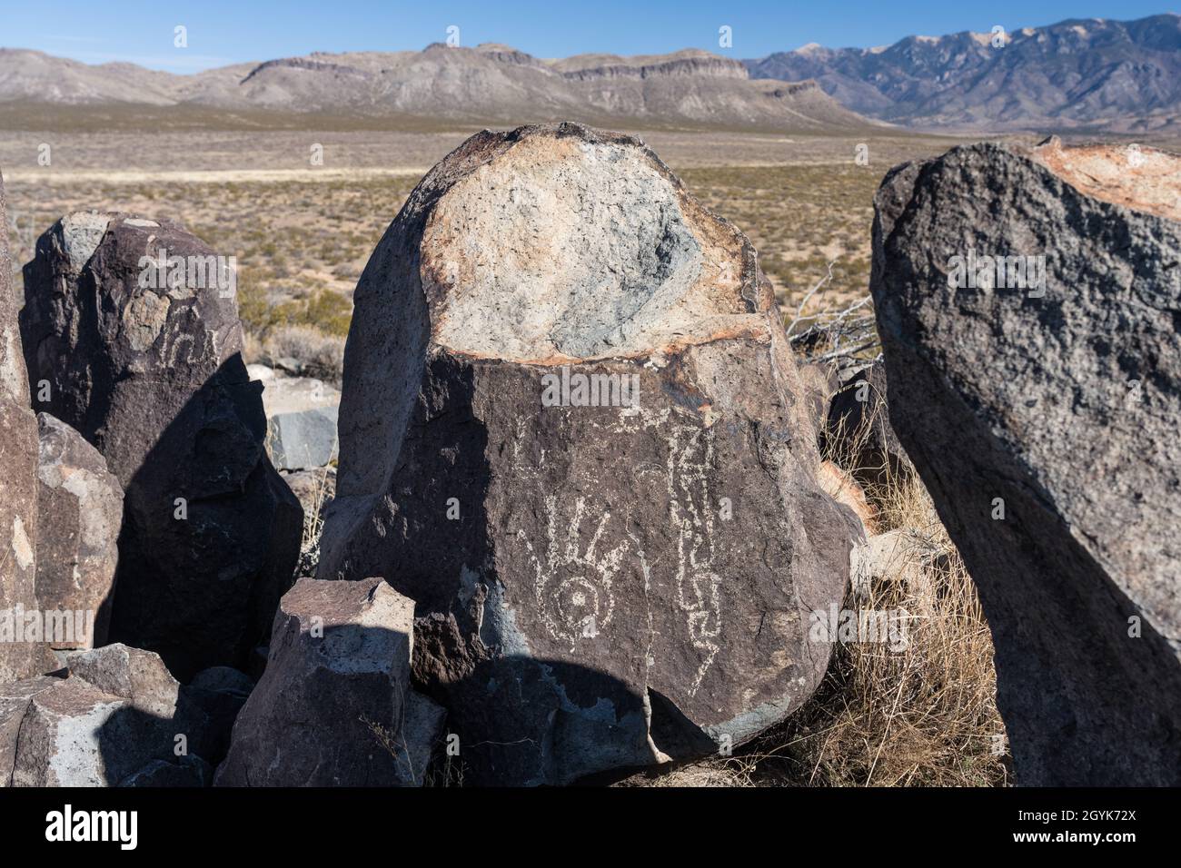 Ein Handabdruck und eine Schlange, die auf einem Basaltsteinblock in der Petroglyph-Stätte Three-Flues, New Mexico, geschnitzt wurde. Stockfoto