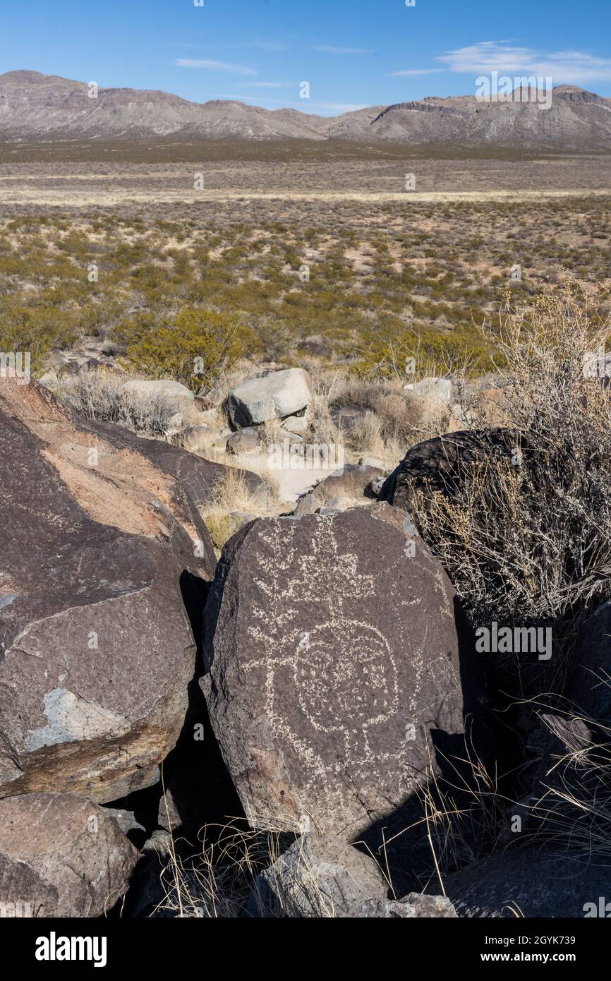 Ein menschliches Gesicht, das auf einem Basaltsteinbrocken in der Petroglyph-Stätte Three-Flues, New Mexico, geschnitzt wurde. Stockfoto