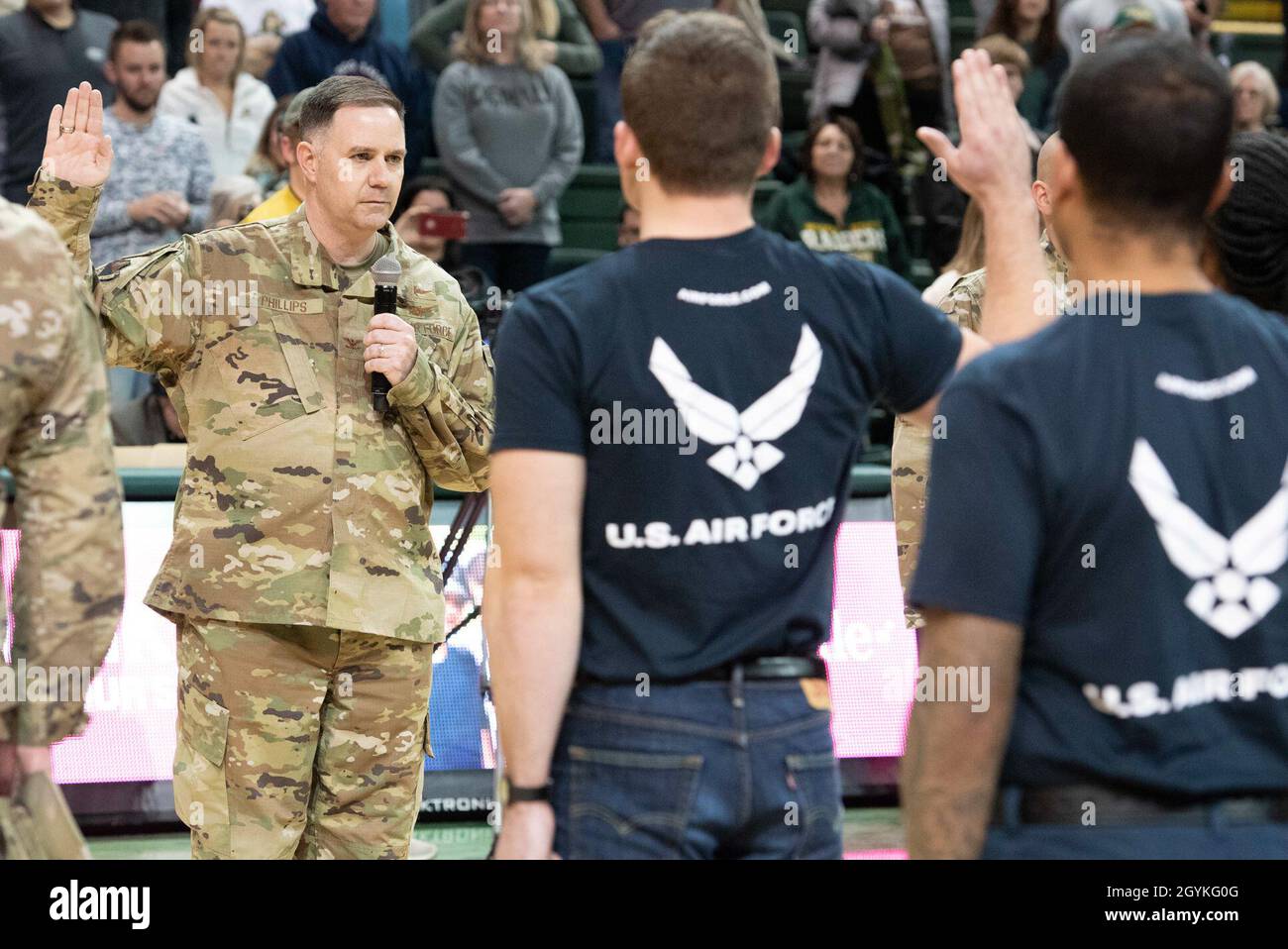 Der Vizekommandant des 88. Luftwaffenflügels Michael Phillips der US-Luftwaffe verwaltet den Eid der Einberufung an 19 Mitglieder des verspäteten Einberufungsprogramms während der Männer-Basketball-Militärwerbenacht der Wright State University im Nutter Center in Fairborn, Ohio, am 18. Januar 2020. Mitglieder des Militärs präsentierten auch den Spielball, sangen die Nationalhymne und präsentierten die Farben während der Zeremonien vor dem Spiel. (USA Luftstreitkräfte-Foto/Wesley Farnsworth) Stockfoto