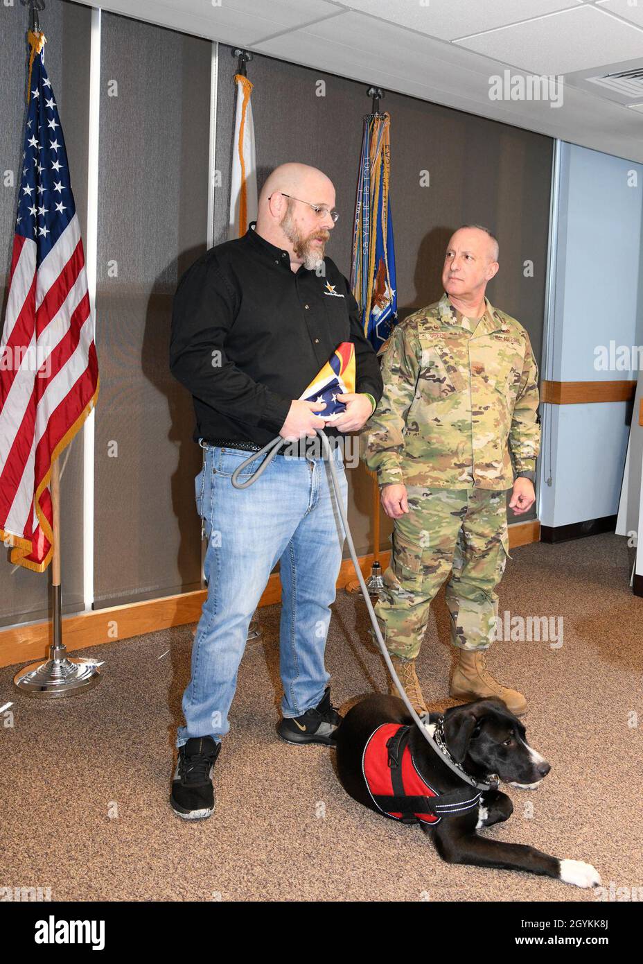 Brian Miller, der Leiter des Kapitels von Honor and Remember in Massachusetts, überreichte Col. Peter T. Green III, dem Befehlshaber des 104. Kampfflügels, eine Ehrenflagge. Honor and Remember erkennt das Opfer gefallener Dienstmitglieder an und tröstet ihre Familien. (US Air National Guard Fotos von Meister Sgt. Lindsey Sarah Watson-Kirwin) Stockfoto