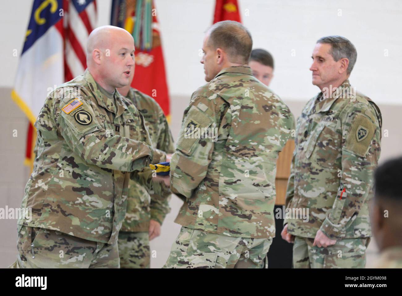 Der US-Armeekapitän Earle J. Pope (rechts), Kommandeur von Alpha Battery, 5. Bataillon, 113. Field Artillery Regiment, übergibt die Einsatzflagge der Einheit an den US-Armeekolon Tobin Clifton (Mitte), Kommandeur des 60. Truppenkommandos, während der Begrüßungszeremonie der Einheit in einer Waffenkammer, Greensboro, North Carolina, am 24. Januar 2020. Alpha Battery kehrte kürzlich von einem Einsatz im Nahen Osten zur Unterstützung der Sentinel der Operation Freedom nach Hause zurück. (USA Army National Guard Foto von Sgt. Jamar Marcel Pugh, 382. Abteilung für öffentliche Angelegenheiten/entlassen) Stockfoto