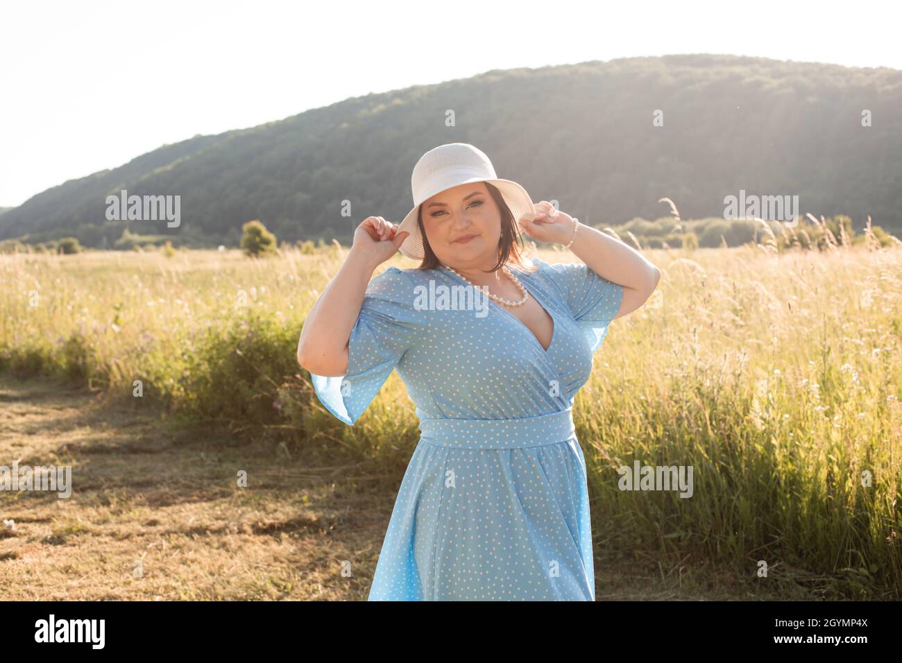 Ehrliche Frau im Hut auf dem Ackerland genießen Sie den Sommer Stockfoto