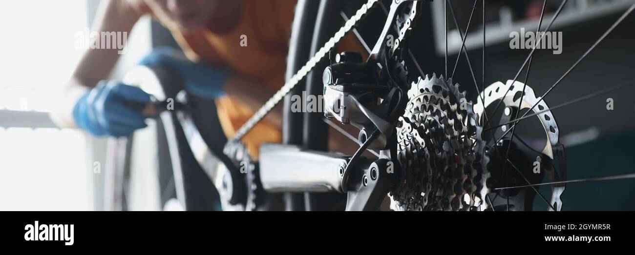 Frau Werkstatt in Gummihandschuhen Reparatur Fahrrad mit Werkzeugen Nahaufnahme Stockfoto