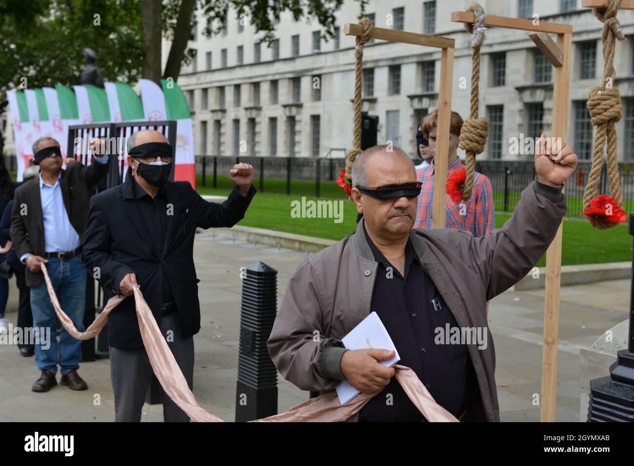 London, Großbritannien. Okt. 2021. Die Demonstranten, die mit verbundenen Augen auf einer Kundgebung gegenüber der Downing Street 10 am Tag des Internationalen Tages gegen die Todesstrafe zu sehen waren, verurteilten die anglo-iranische Gemeinschaft die Teilnahme des iranischen Präsidenten an der COP26-Konferenz in Glasgow. Kredit: SOPA Images Limited/Alamy Live Nachrichten Stockfoto