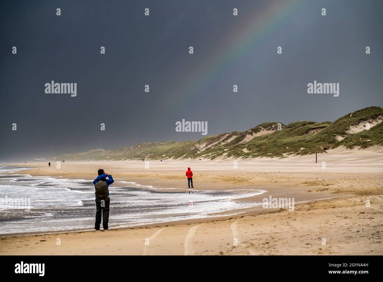 Spaziergänger am Strand, dunkle Sturmwolken, raues Meer, Herbst an der Nordsee in Nordholland, zwischen den Städten Egmond aan Zee und Bergen aan Zee, Stockfoto