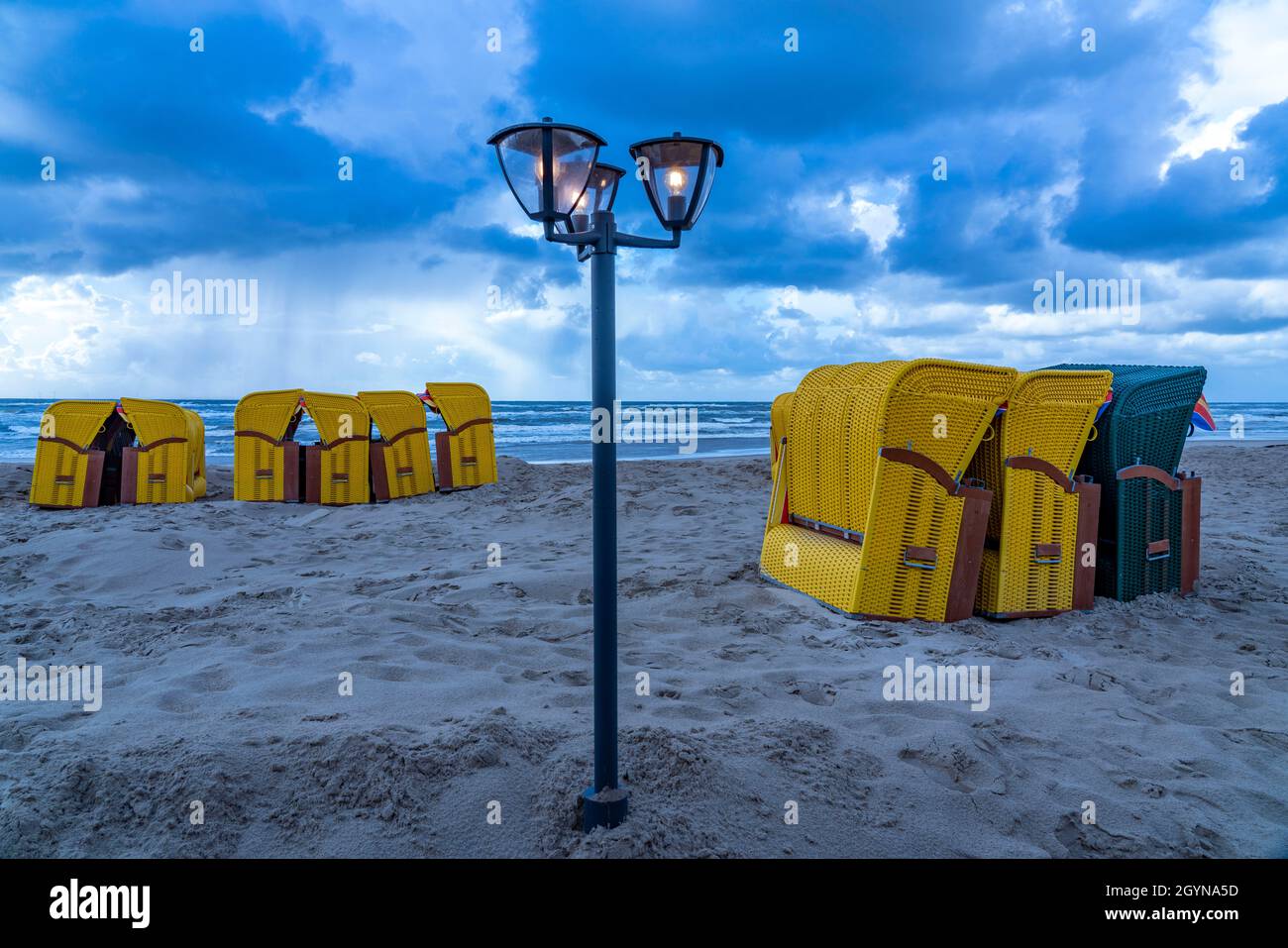 Ende der Saison am Strand, dunkle Sturmwolken, raues Meer, Herbst an der Nordsee in Nordholland, in der Nähe der Stadt Egmond aan Zee, Liegestühle Stockfoto