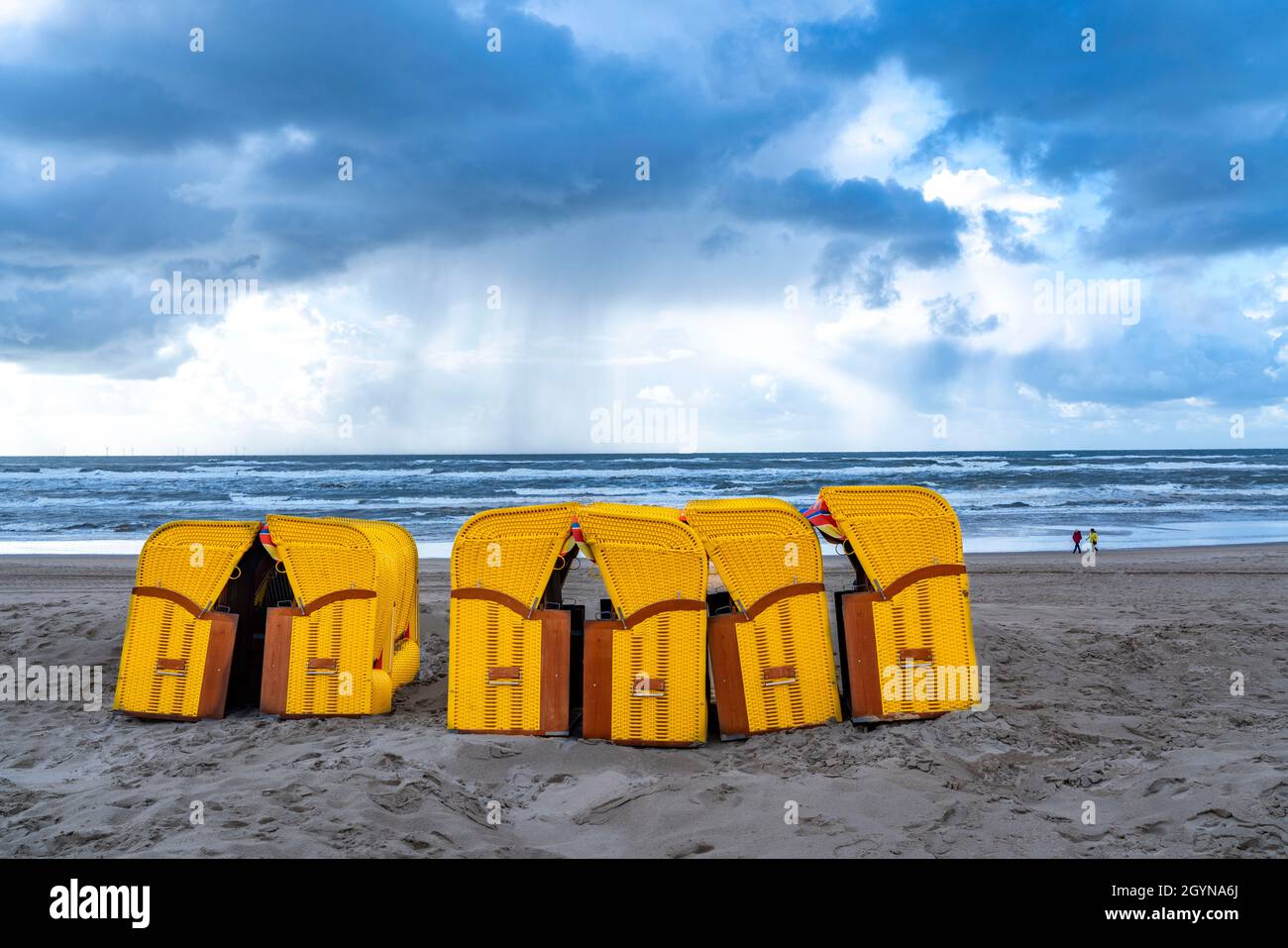Ende der Saison am Strand, dunkle Sturmwolken, raues Meer, Herbst an der Nordsee in Nordholland, in der Nähe der Stadt Egmond aan Zee, Liegestühle Stockfoto