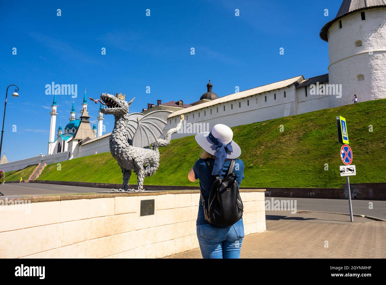 Kasan, Russland - 16. Juni 2021: Junge Frau fotografiert die Drachenstatue im Kasan Kreml, Tatarstan, Russland. Der Kreml ist die wichtigste Touristenattraktion von Ka Stockfoto