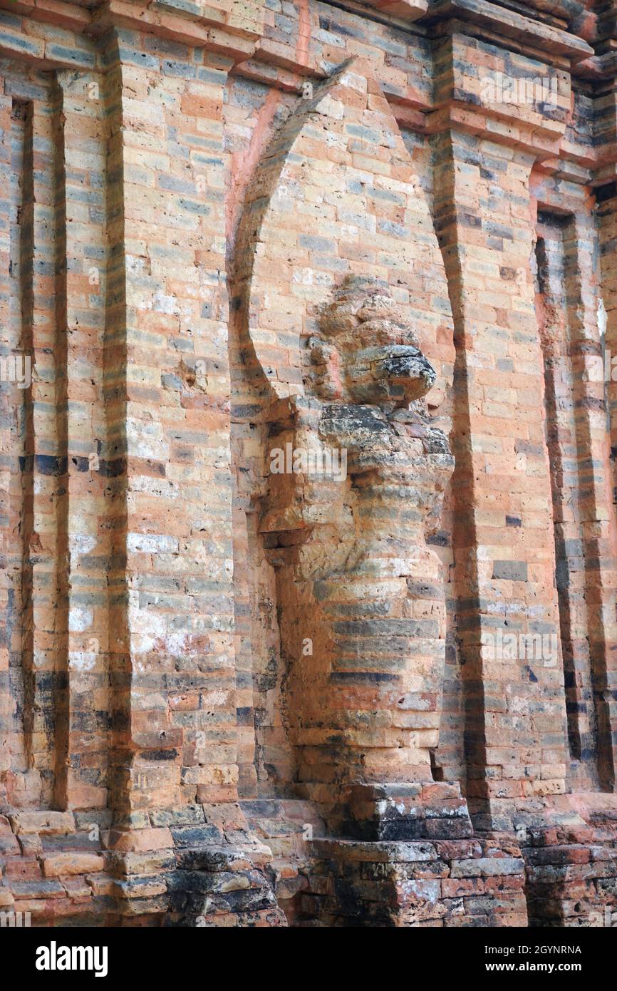 Abgewinkelte Ansicht einer verwitterten Figur auf der Außenseite eines der alten Po Nagar Cham Towers, gelegen auf dem Cù Lao Berg in Nha Trang, Vietnam Stockfoto