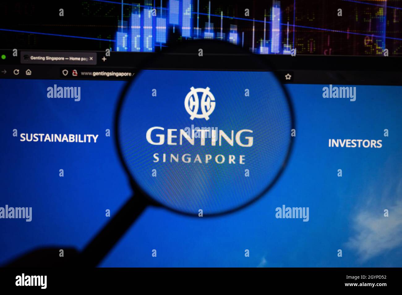 Genting Singapore Unternehmenslogo auf einer Website mit verschwommenen Börsenentwicklungen im Hintergrund, auf einem Computerbildschirm gesehen Stockfoto