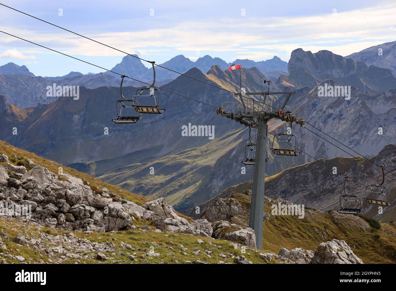 Leerer Sessellift in den alpen im Sommer mit Bergpanorama im Hintergrund Stockfoto
