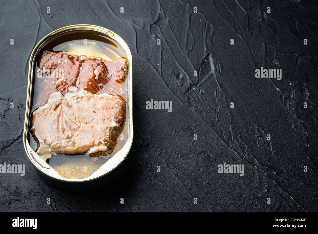 Set aus geräuchertem Fisch aus der Dose mit wildem Alaska-Lachs, auf schwarzem Hintergrund, mit Textraum und Platz für Text Stockfoto