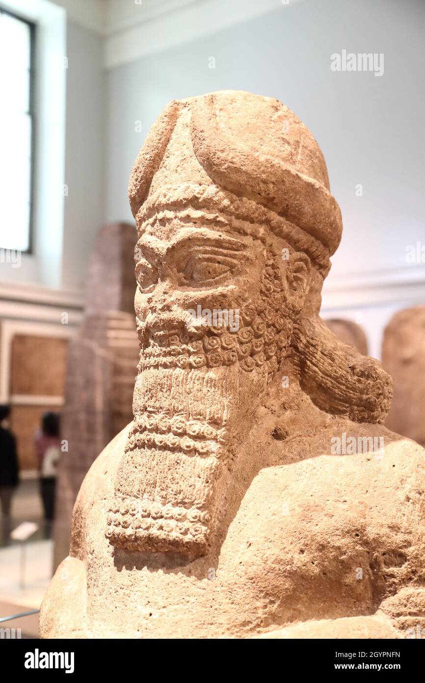 Assyrische Kalksteinfigur eines begleitenden gottes aus dem Tempel der NABU in Nimrud im britischen Museum, London, Großbritannien Stockfoto