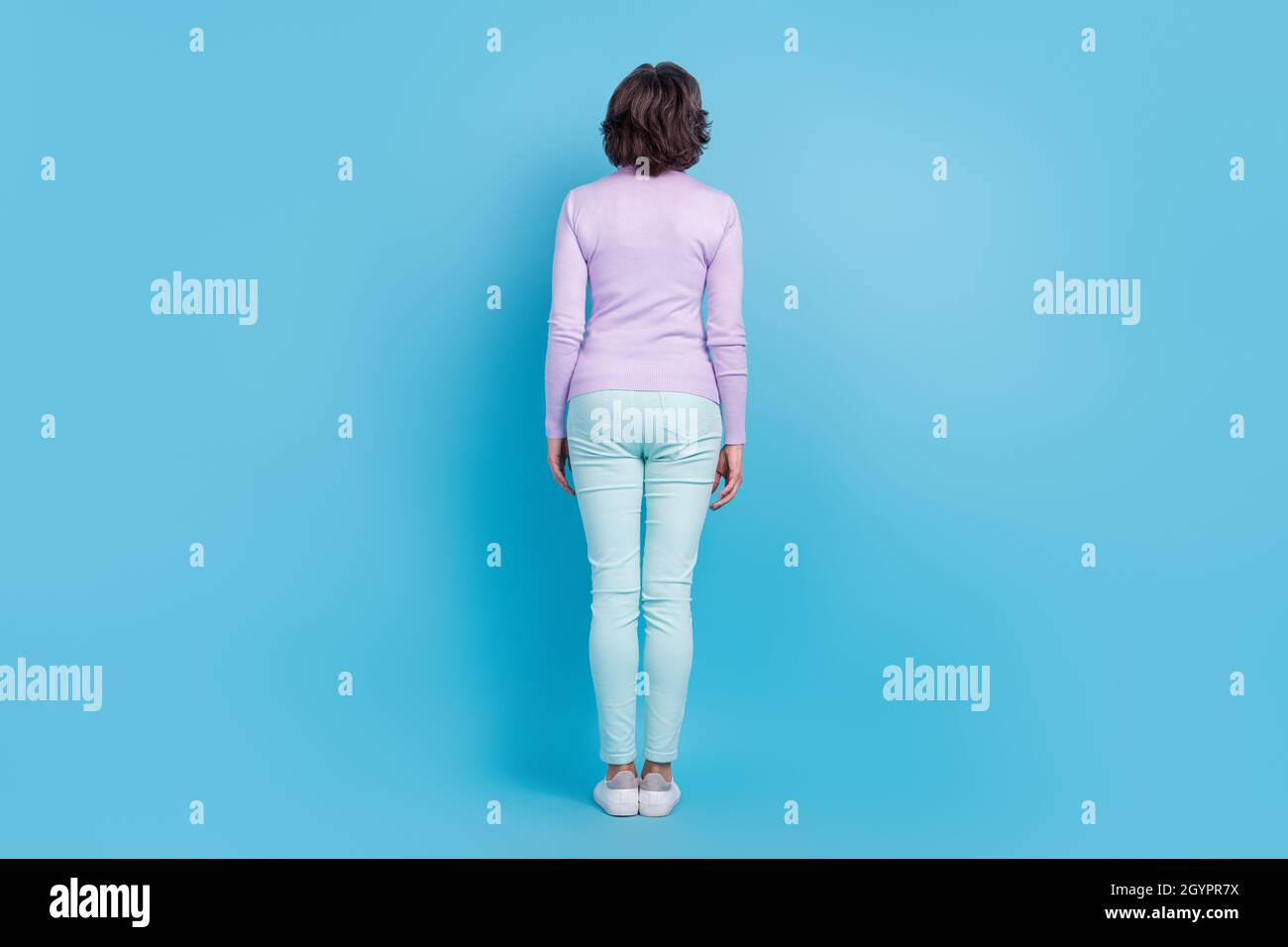Full Size Rückseite Wirbelsäule Ansicht Foto von reifen Frau Inkognito anonym isoliert über blauen Hintergrund Stockfoto