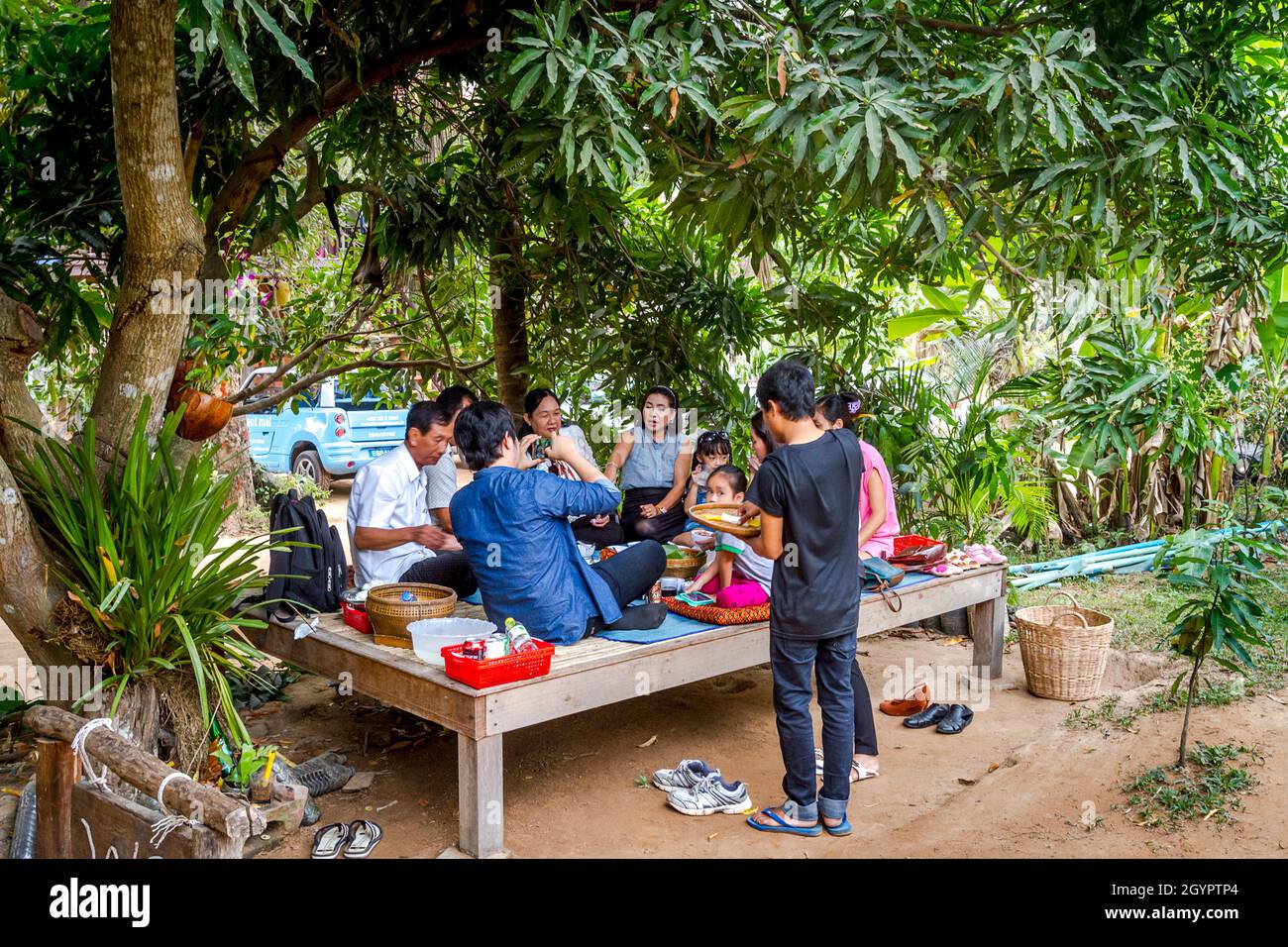 Eine Gruppe, die Khmer-Essen auf einer sonnenoffenen Plattform isst. Stockfoto