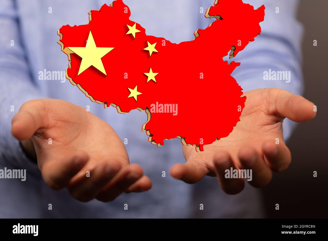 3D-Darstellung der Flagge der Volksrepublik China in einer Karte, die auf menschlichen Händen schwebt Stockfoto