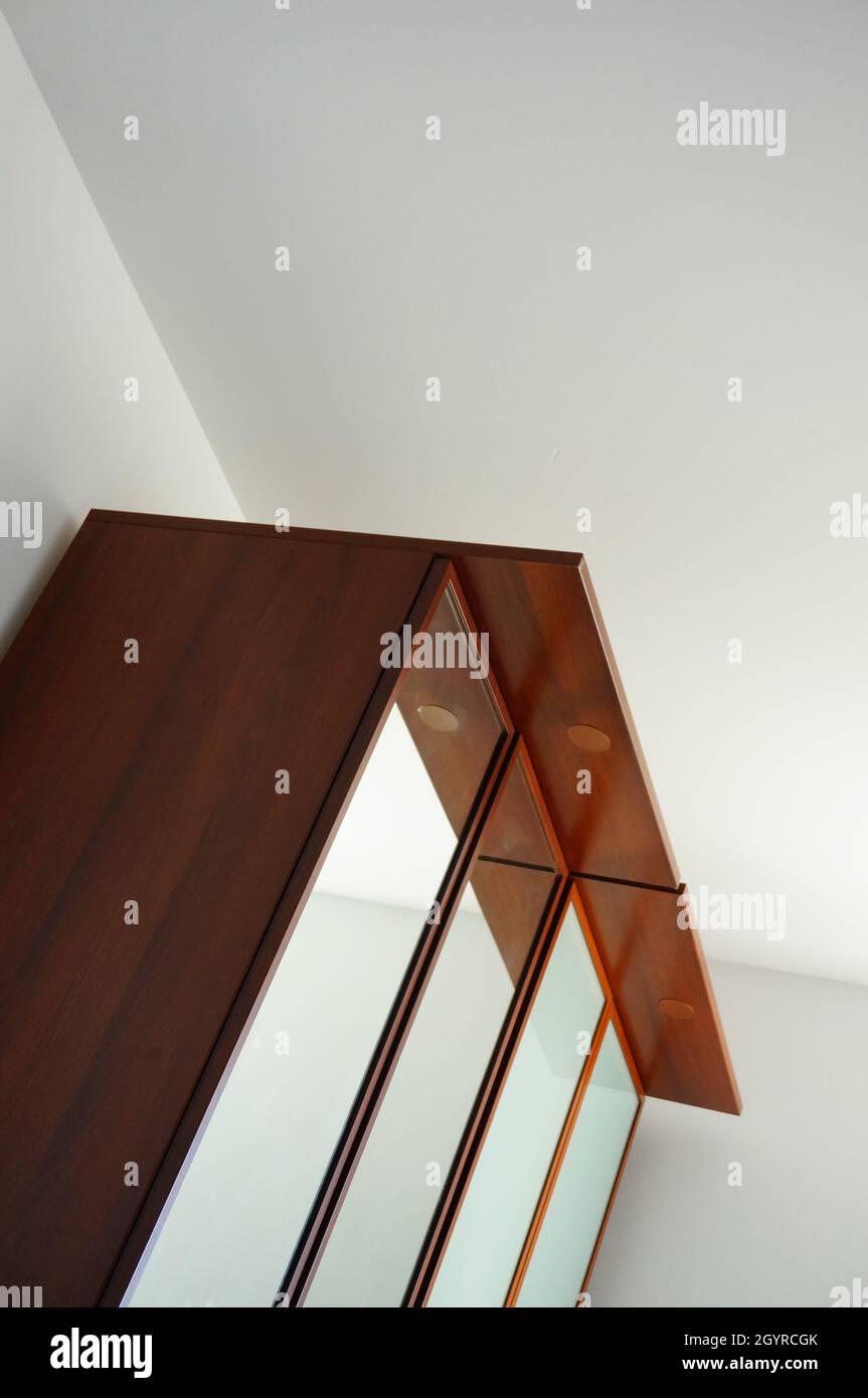Holzschrank mit Spiegeltür an der Ecke Stockfoto